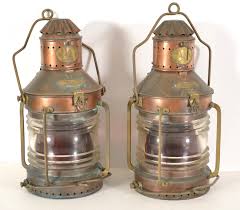 Lot - Pair of Neptune copper ship's anchor lanterns with molded glass lenses with red screens and two handles, early 20th Century. Unaltered. Height 22 in.