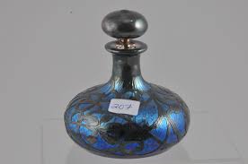 Lot - Loetz and sterling overlay Art Glass bottle and stopper. Blue iridescent oil spot glass. Acid etched signed on the base. Elaborate intricate silver overlay with central cartouche bearing a fancy