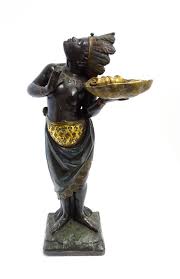 Sold at Auction: A 19thC carved and painted figural dumb waiter modelled as a female Blackamoor with feather headdres