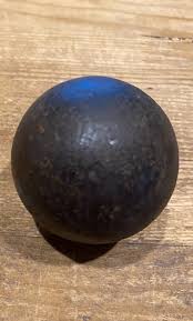 I saw this black heavy sphere with dents all over at a ...