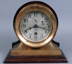 Sold at Auction: PC – Antique Chelsea brass ship's clock; round, marked on back 'Chelsea Clock Co 67842 & 2959' mounted on a nice walnut or mahogany stepped back shelf/frame; base marked @