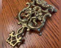 Vintage Footed Trivet in Gold - Ornate With Cherubs Cupids ...