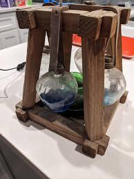 Apple shaped glass containers hanging from wooden structure ...