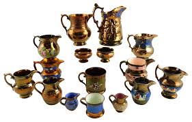 Lot - Sixteen pieces of lusterware, 19th/early 20th C., consisting of twelve pitchers, two matching footed bowls, and two handled cups, highlights include: English lusterware pitcher with blue enamel, c. 1860's, with