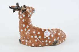 Lot - Porcelain vase. China. 19th century. Molded in the form of a reclining deer with a ling chih in its