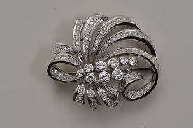 Lot - Platinum and diamond brooch. Contains 9 central bezel-set round brilliant d
