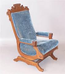 Lot - WALNUT EASTLAKE VICTORIAN PLATFORM ROCKER WITH BLUE UPHOLSTERY AND OPEN FLORAL CARVED CREST