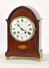 A mahogany case shelf or mantel clock with decorative inlays ...