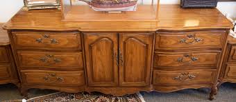 Lot - French Provincial style serpentine dresser having six drawers centering a pair of cupboard doors.