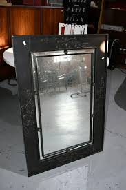 Sold at Auction: Ornate wall mirror, decorative steel frame with black painted finish, fitted with beveled mirror, can be hung horizontally or vertically, heavy gauge hanging chain to back. 100cm x 70cm