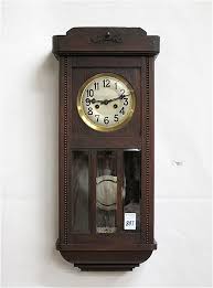 Lot - TWO GERMAN OAK BOX-CASE WALL CLOCKS: Gustav Becker, Silesia, c. 1910-1926; Junghans, c. 1913. Both clocks have springwound, 8-day, time/chime movements. Respective case lengths: 30.25 and 30.75 inches.