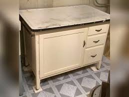 Vintage wood w/enamel top kitchen cabinet, 33” x 41 1/2” x 25”. Has wire shelf, lid holder on inside door and towel bar on outside end. - Northern Kentucky Auction, LLC