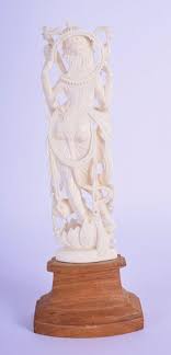 Sold at Auction: A 19TH CENTURY ANGLO INDIAN CARVED IVORY FIGURE OF A BUDDHISTIC DEITY upon a wooden base. Ivory 15 cm high.