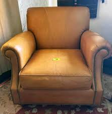 Sold at Auction: Furniture: oversized leather arm chair in tan/yellow/squash with brass rivets trim NO SHIPPING