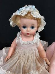 Lot - (2) 7" VINTAGE HARD PLASTIC MADAME ALEXANDER "LITTLE GENIUS" DOLLS IN TAGGED DRESSES. ONE WEARS PINK COAT AND MATCHING HAT AND OTHE...