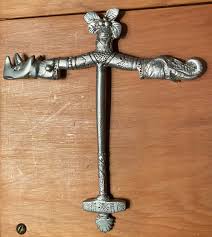 Metallic cross shaped object with a rhino and an elephant ...