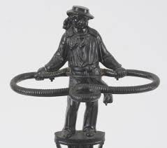 Lot - Sailor form cane or umbrella stand, marked Marcy Co Foundry 1927. New York, black painted with original drip pan. Height 27 in. Width 21.5 in. Depth 9.5 in.