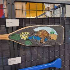 It may be our last week of featuring artist's for the Paddle Art Contest, but voting for the People's Choice Award will remain open until August 20th! This week's featured artists are: