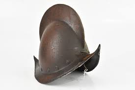 At Auction: A 16th century Spanish style morion helmet, with applied roundels, height 28cm.