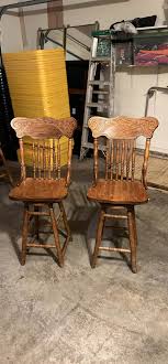 Wood bar stools that I think are oak, dimension from the floor to the top of the seat is 25”. Both stools are sturdy with no issues and they both swivel. Pickup