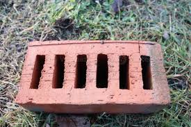 This image depicts a red brick structure featuring hollow ...