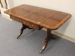Lot - 19th century English Regency Rosewood Sofa table with two real and two false drawers. Also with unusual inlaid pattern around top and leaves. Inlaid drawers and pedestals. Leaf form brass