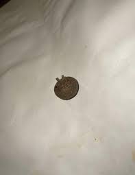 Slightly squashed Spherical item, 12mm in radius, nonferrous, light for its weight, with engraved letters, it had a full metal hook/loop, has a circular embossed top with letters engraved. : r/whatisthisthing