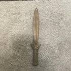 This is a lump of green glass with white inclusions or spots in it. The glass has sharp and smooth edges and appears to have been shattered. It was brought back by