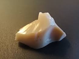 Found this in the thriftstore in a bunch of minerals. What could it be, it is to light for glass imho. It is radioactive and look like it has Uranyl in it