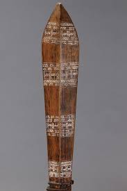 Sold at Auction: WAR CLUB, SAMOA ISLANDS. Carved and engraved hardwood and lime. A large, hand-carved wooden war club with a flat, blade-like face, both sides of the blade are decorated with