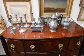 Sold at Auction: Federal Mahogany Sideboard having bowed front over conforming case of three drawers over two center doors flanked by two bottle drawers, all on turned and fluted legs, circa 1830