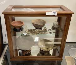ANCIENT ARTIFACTS IN DISPLAY CASE - 12 ITEMS INCLUDING EGYPTIAN SHABTI & BEADS, SILVER & BRONZE COIN, ROMAN GLASS, COLOMBIAN FISH BOWL & MALAYSIAN NANHAI SHIPWRECK CELADON - Southgate Auction Rooms