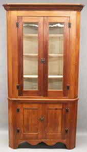 Sold at Auction: Furniture – NO SHIPPING - Antique two-piece corner cupboard; softwood stained cherry; double blind door base with scalloped skirt up to a tall double glass door top with tall