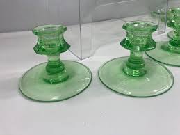 Sold at Auction: URANIUM GLASS CANDLESTICKS, BISCUIT JAR, AND DISHES