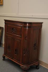 Lot - 20th century Chinese carved wood small bar cabinet with lift top revealing sectional shelves. Two doors below. 32" wide, 18" deep, 38" high.