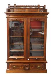 Lot - Eastlake bookcase with ornately carved and pierced gallery top over two glass panel doors, late 19th C., rosewood with veneered pane...