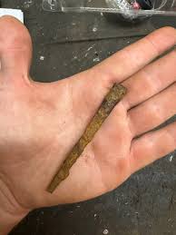 What is the origin of an old nail found in a graveyard?