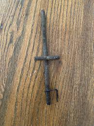5” metal rods, cross shaped with a hook of some sort. Found ...