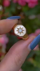 An 18ct gold signet ring engraved with an eight point star ...